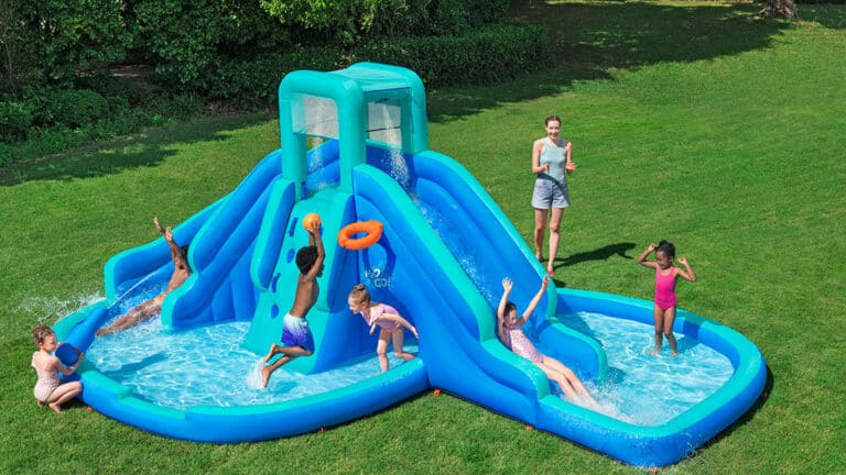 A bunch of kids playing on an H2OGO! water park with 2 water slides, a splash pool, a tunnel, a basketball hoop and more.