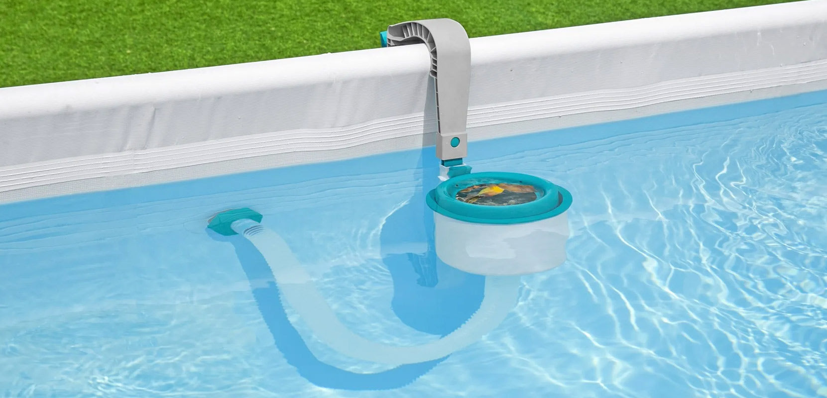 A close-up of a surface skimmer hanging on the side of a Bestway above ground pool with grass in the background. 